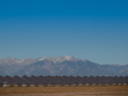 A series of large solar panels forms a symmetrical line at a power plant in the San Luis Valley of central Colorado. These panels utilize a tracking system to follow the sun, collecting its energy and using photovoltaic cells to transform the sunlight intのeditorial素材
