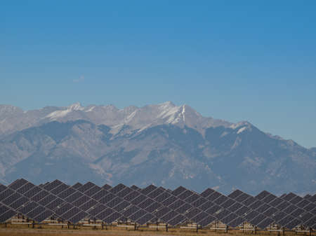 A series of large solar panels forms a symmetrical line at a power plant in the San Luis Valley of central Colorado. These panels utilize a tracking system to follow the sun, collecting its energy and using photovoltaic cells to transform the sunlight intのeditorial素材