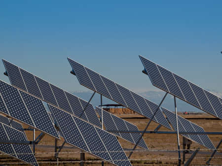 A series of large solar panels forms a symmetrical line at a power plant in the San Luis Valley of central Colorado. These panels utilize a tracking system to follow the sun, collecting its energy and using photovoltaic cells to transform the sunlight intのeditorial素材