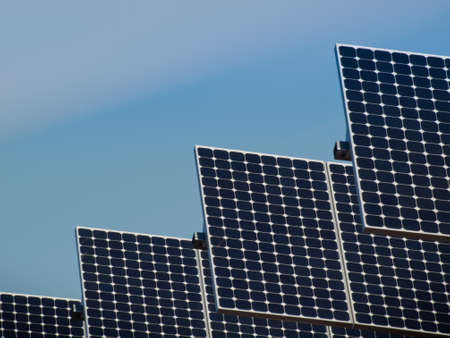 A series of large solar panels forms a symmetrical line at a power plant in the San Luis Valley of central Colorado. These panels utilize a tracking system to follow the sun, collecting its energy and using photovoltaic cells to transform the sunlight intのeditorial素材