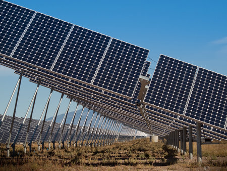 A series of large solar panels forms a symmetrical line at a power plant in the San Luis Valley of...