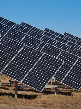 A series of large solar panels forms a symmetrical line at a power plant in the San Luis Valley of central Colorado. These panels utilize a tracking system to follow the sun, collecting its energy and using photovoltaic cells to transform the sunlight intのeditorial素材
