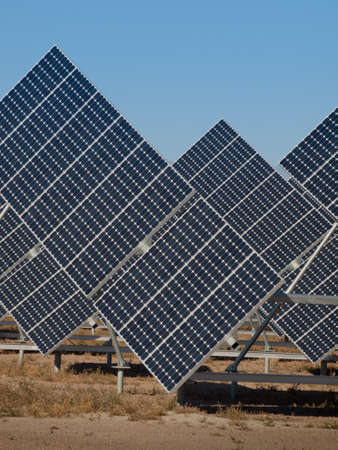 A series of large solar panels forms a symmetrical line at a power plant in the San Luis Valley of central Colorado. These panels utilize a tracking system to follow the sun, collecting its energy and using photovoltaic cells to transform the sunlight intのeditorial素材
