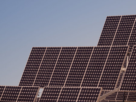A series of large solar panels forms a symmetrical line at a power plant in the San Luis Valley of central Colorado. These panels utilize a tracking system to follow the sun, collecting its energy and using photovoltaic cells to transform the sunlight intのeditorial素材