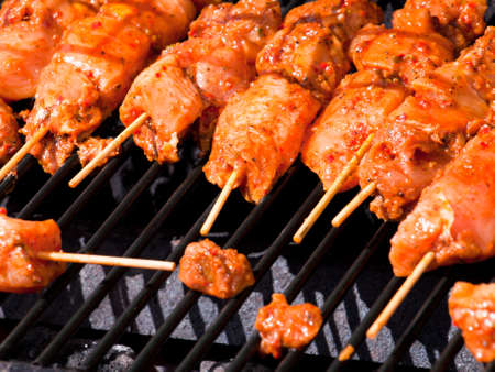 Close shot of chicken kebabs cooking on a barbecue.の写真素材