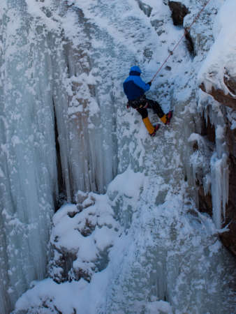 Alpinist ascenting a frozen waterfall in Ice park, Ouray.の写真素材