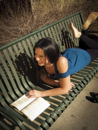 Young woman reading book in the park.の写真素材