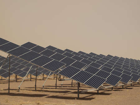 A series of large solar panels forms a symmetrical line at a power plant in the San Luis Valley of central Colorado. These panels utilize a tracking system to follow the sun, collecting its energy and using photovoltaic cells to transform the sunlight intの写真素材