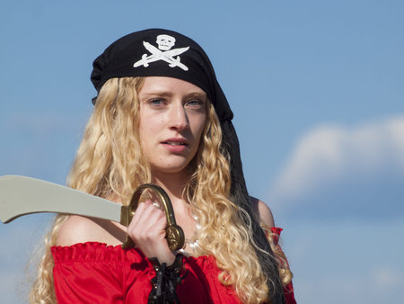 Beautiful young female pirate in red dress.の写真素材