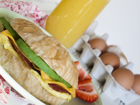 Croissant breakfast sandwich with orange juice served for breakfast.の写真素材