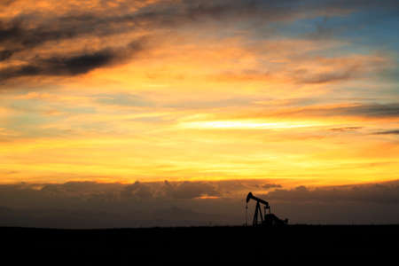 A pumpjack silhoutte with dramatic sunset.の写真素材