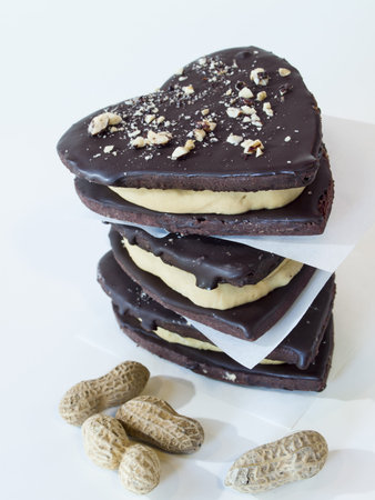 Chocolate cookies with peanut butter filling on white background.の写真素材