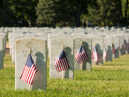 Endless row of white marble gravestones continues above hilltop at the Fort Logan National Cemetery...