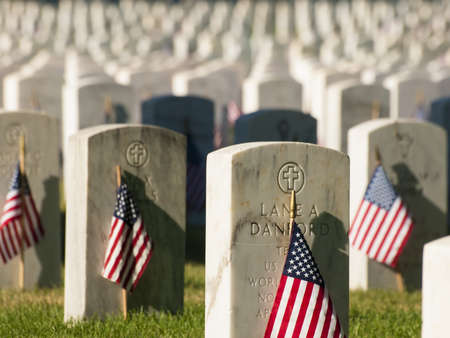 Endless row of white marble gravestones continues above hilltop at the Fort Logan National Cemetery in Denver, Colorado. American flags decorating each grave to mark the Memorial Day.のeditorial素材