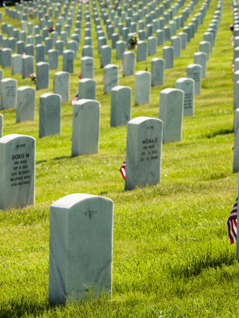 Endless row of white marble gravestones continues above hilltop at the Fort Logan National Cemetery...