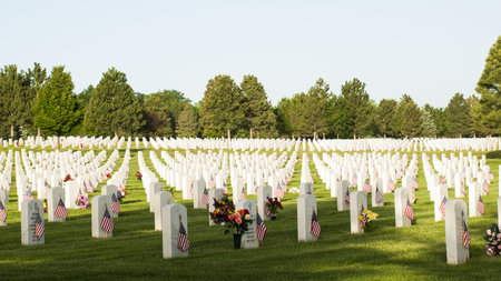 Endless row of white marble gravestones continues above hilltop at the Fort Logan National Cemetery...