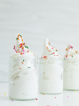 Frozen soft-serve yogurt in glass on white background.