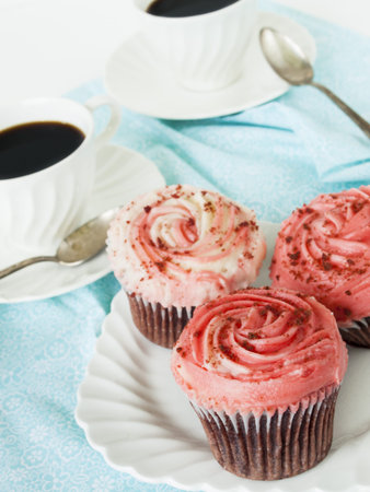 Gourmet red welveet cupcake on white plate.