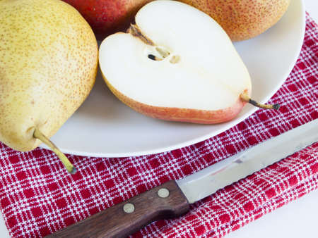 Ripe pear on white background. The cultivation of the pear in cool temperate climates extends to the remotest antiquity, and there is evidence of its use as a food since prehistoric times.の写真素材