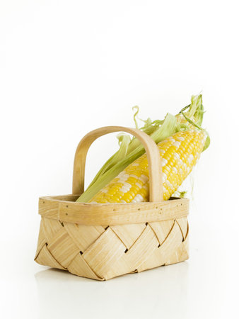 Olathe sweet corn in basket on white background.