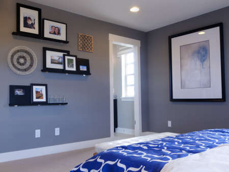 Modern master bedroom with blue wall and white linens.のeditorial素材