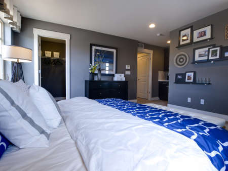 Modern master bedroom with blue wall and white linens.のeditorial素材