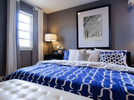 Modern master bedroom with blue wall and white linens.のeditorial素材