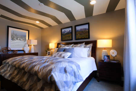 Modern master bedroom with large pictures and custom painted ceiling.のeditorial素材