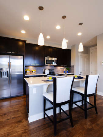 Modern kitchen with wood cabinets and stainless appliances.のeditorial素材