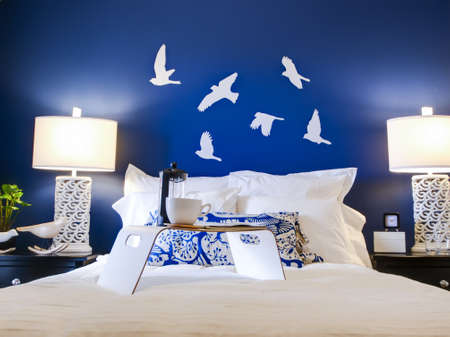 Modern master bedroom with blue wall and white linens.のeditorial素材