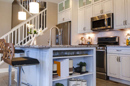 Modern kitchen with white cabinets and stainless appliances.のeditorial素材