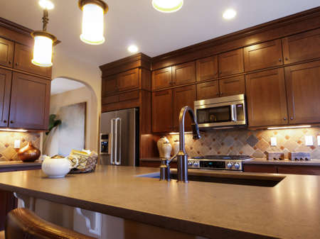 Modern kitchen with wood cabinets and stainless appliances.のeditorial素材