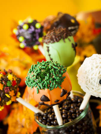 Halloween gourmet cake pops with holiday decor on orange backround.の写真素材