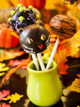 Halloween gourmet cake pops with holiday decor on orange backround.の写真素材
