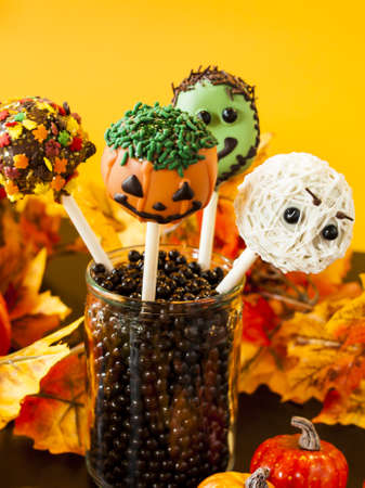 Halloween gourmet cake pops with holiday decor on orange backround.の写真素材