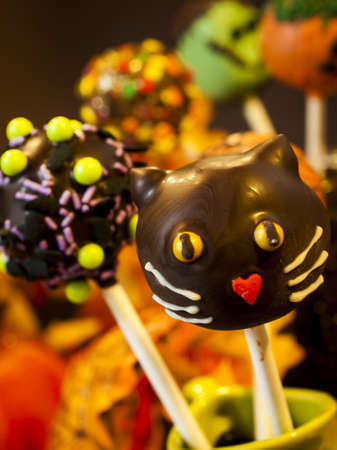 Halloween gourmet cake pops with holiday decor on brown backround.の写真素材