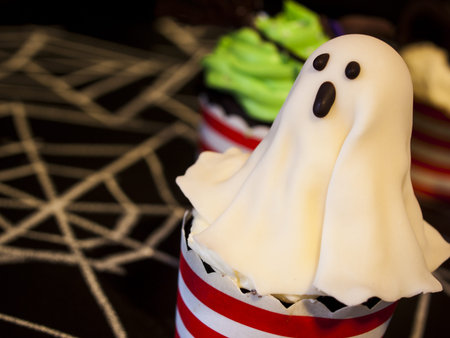Halloween gourmet cupcakes with holiday decor black background.