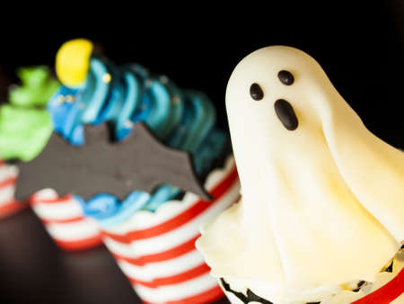 Halloween gourmet cupcakes with holiday decor black background.の写真素材