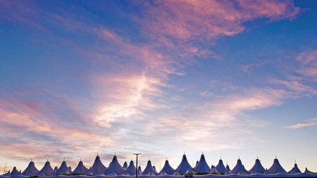 Glowing tents of DIA at sunrise. Denver International Airport well known for peaked roof. Design of...