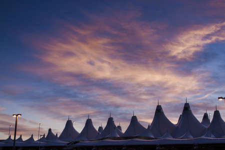 Glowing tents of DIA at sunrise. Denver International Airport well known for peaked roof. Design of roof is reflecting snow-capped mountains.のeditorial素材