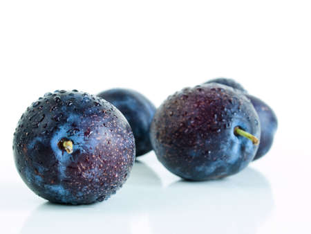 Fresh plums still wet from washing on white background.の写真素材