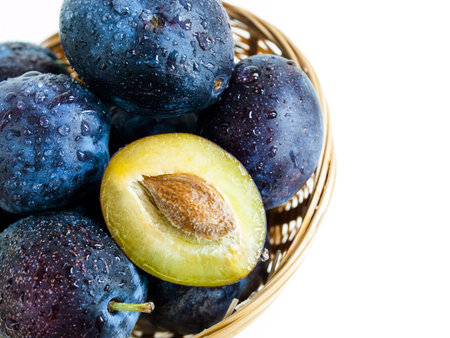 Fresh plums in basket on white background.の写真素材