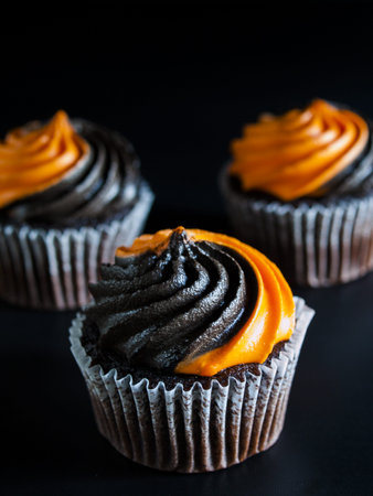 Halloween cupcakes decorated with black and orange swirled icing.の写真素材