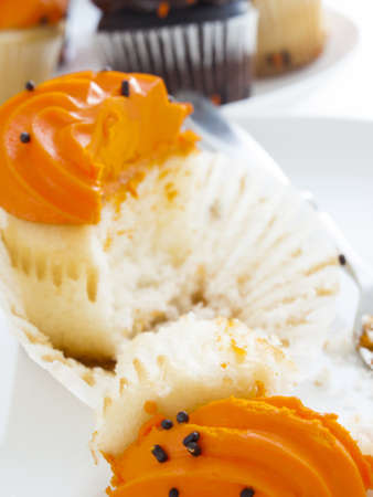 Eating Halloween cupcakes with orange and black icing.の写真素材