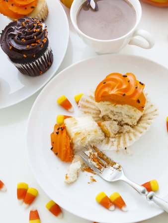 Eating Halloween cupcakes with orange and black icing.の写真素材