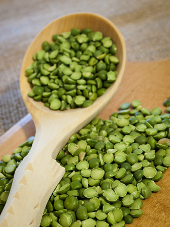 Green speat peas in wooden spoon.