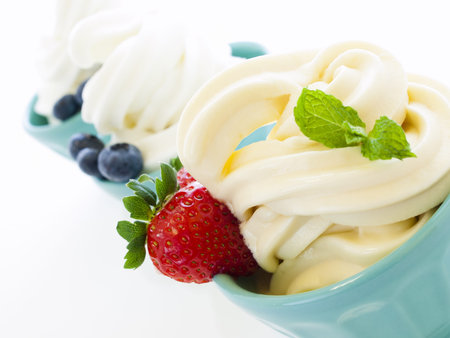 Cup of soft-serve frozen yogurt on white background.