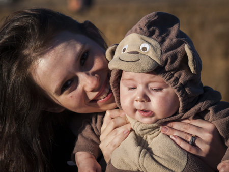 Young mother with her toddler in Halloween costume in corn maze.の写真素材
