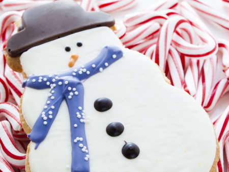 Gourmet snowman cookies with peppermint candy cane on white background.の写真素材