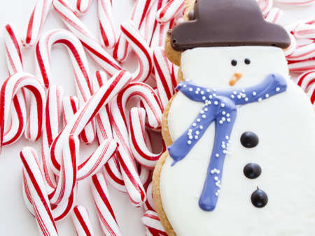 Gourmet snowman cookies with peppermint candy cane on white background.の写真素材